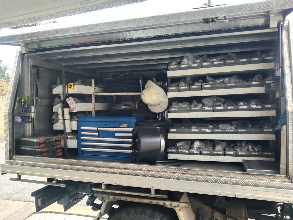 An open silver metal service canopy on a white pickup truck