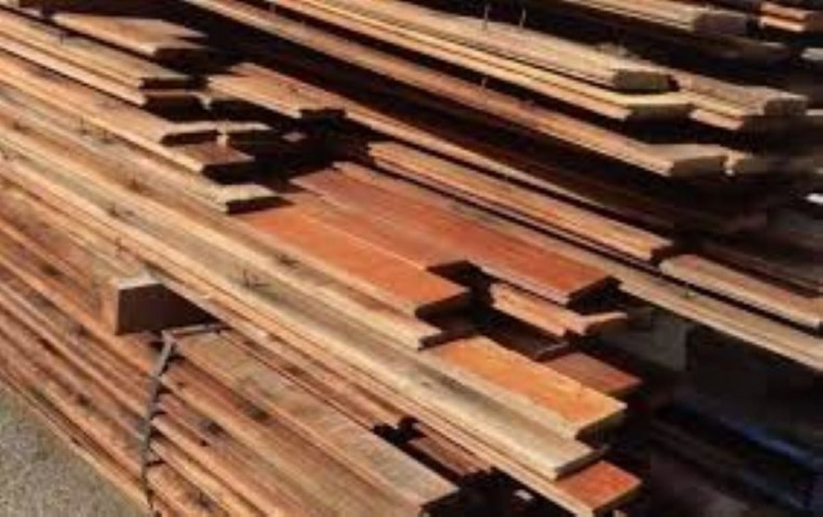 A large, dense stack of weathered wooden planks and boards.