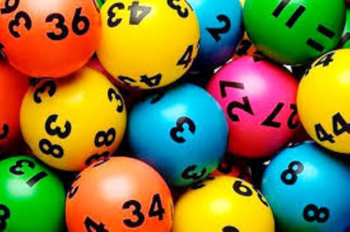 A close-up, overhead view of a pile of vibrant, multi-coloured lottery or bingo balls.